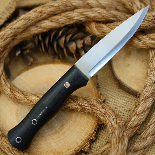 An Adventure Sworn bushcraft knife with black canvas micarta handle scales and black and yellow liners.