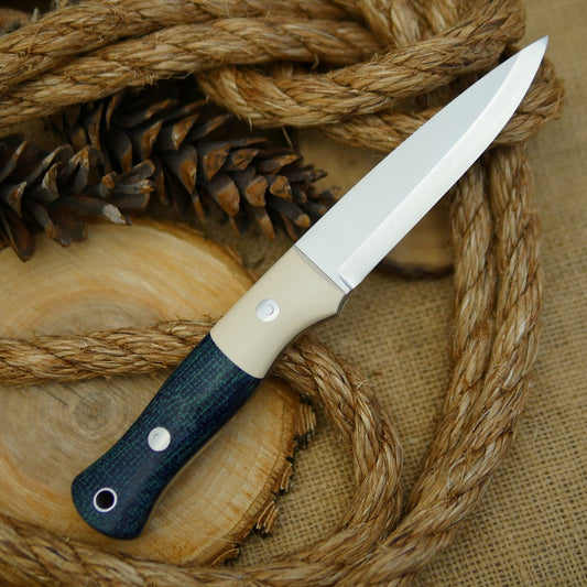 An Adventure Sworn Mountaineer bushcraft knife with navy blue burlap and ivory paper.